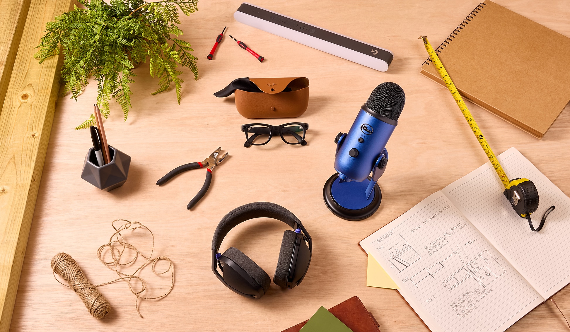 A collection of tech products on a worktop, including a microphone, light, smart glasses and a gaming headset